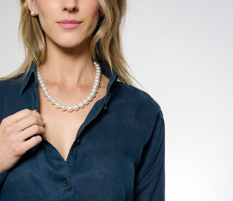 Model wearing a medium length pearl strand on a white background