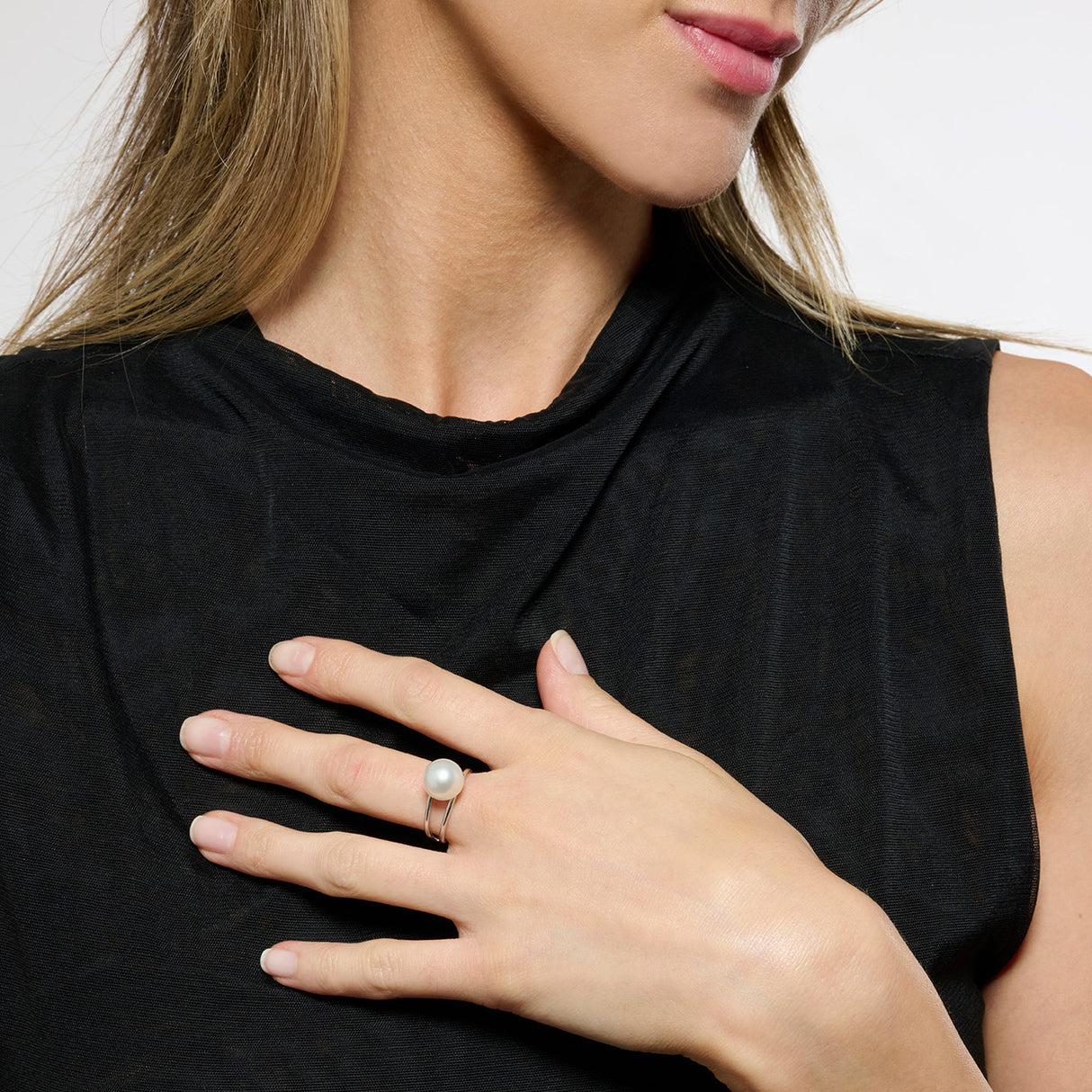 Model wearing black top and a silver double band ring with a pearl set on the top.