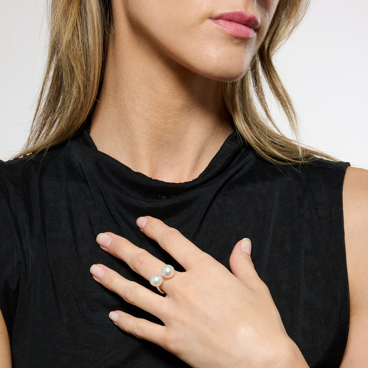 Model wearing black top and a silver ring with 2 pearls set on the top of the band