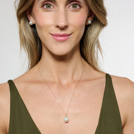Model wearing green triangle tank top and a gold pearl necklace