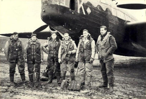 Black and white photo of pilots in front of a plane during the world war