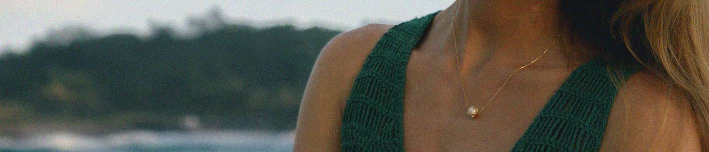 Person wearing a green top with a blurred natural background