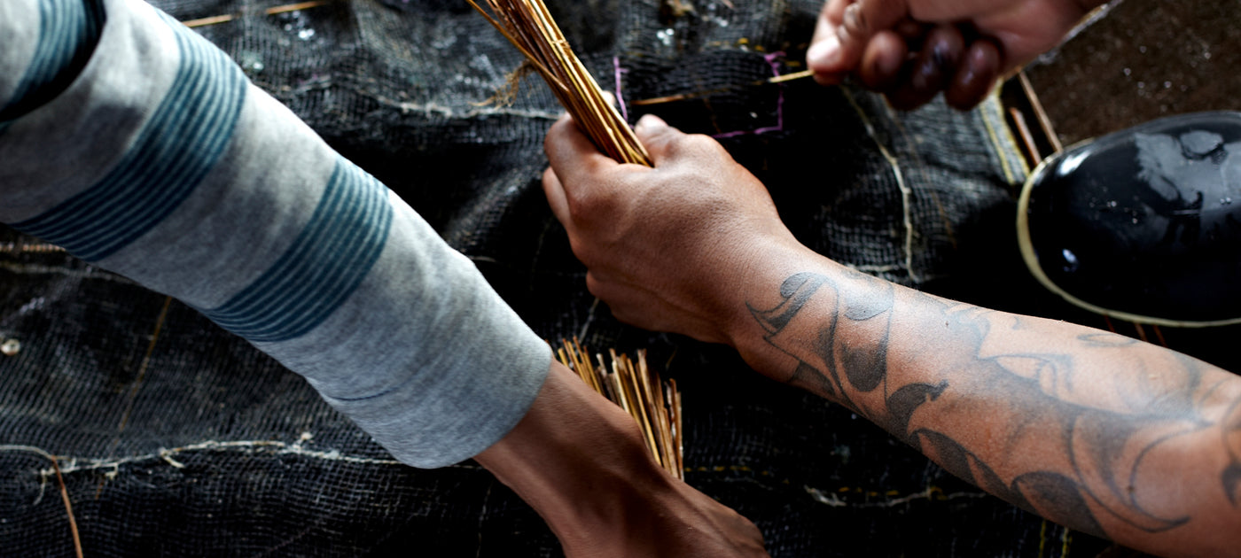 Hands working with straw and mesh black netting