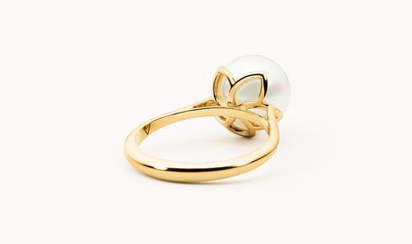 Gold ring with a white pearl on a white background