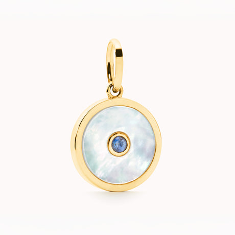 Gold pendant with a blue saphire on a white background