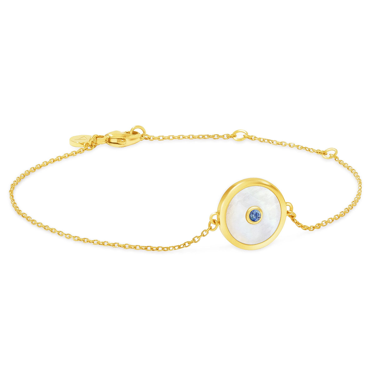 A gold bracelet with a central mother of pearl shell detail surrounded by a blue sapphire on one side, displayed against a white background.