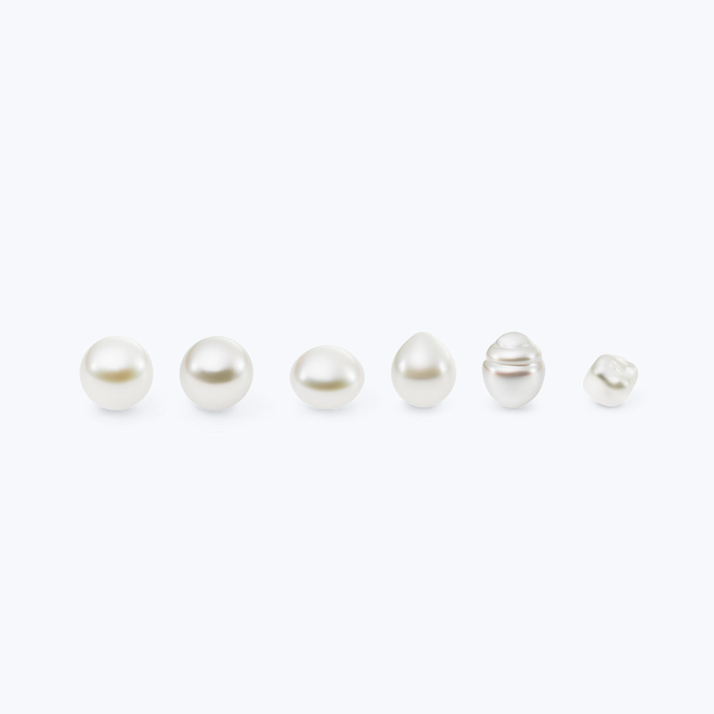 Set of six pearls of varying sizes and shapes on a white background