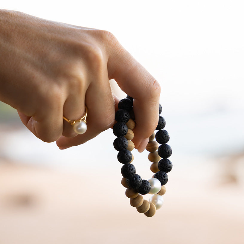 Hand holding a set of beaded bracelets with a blurred background