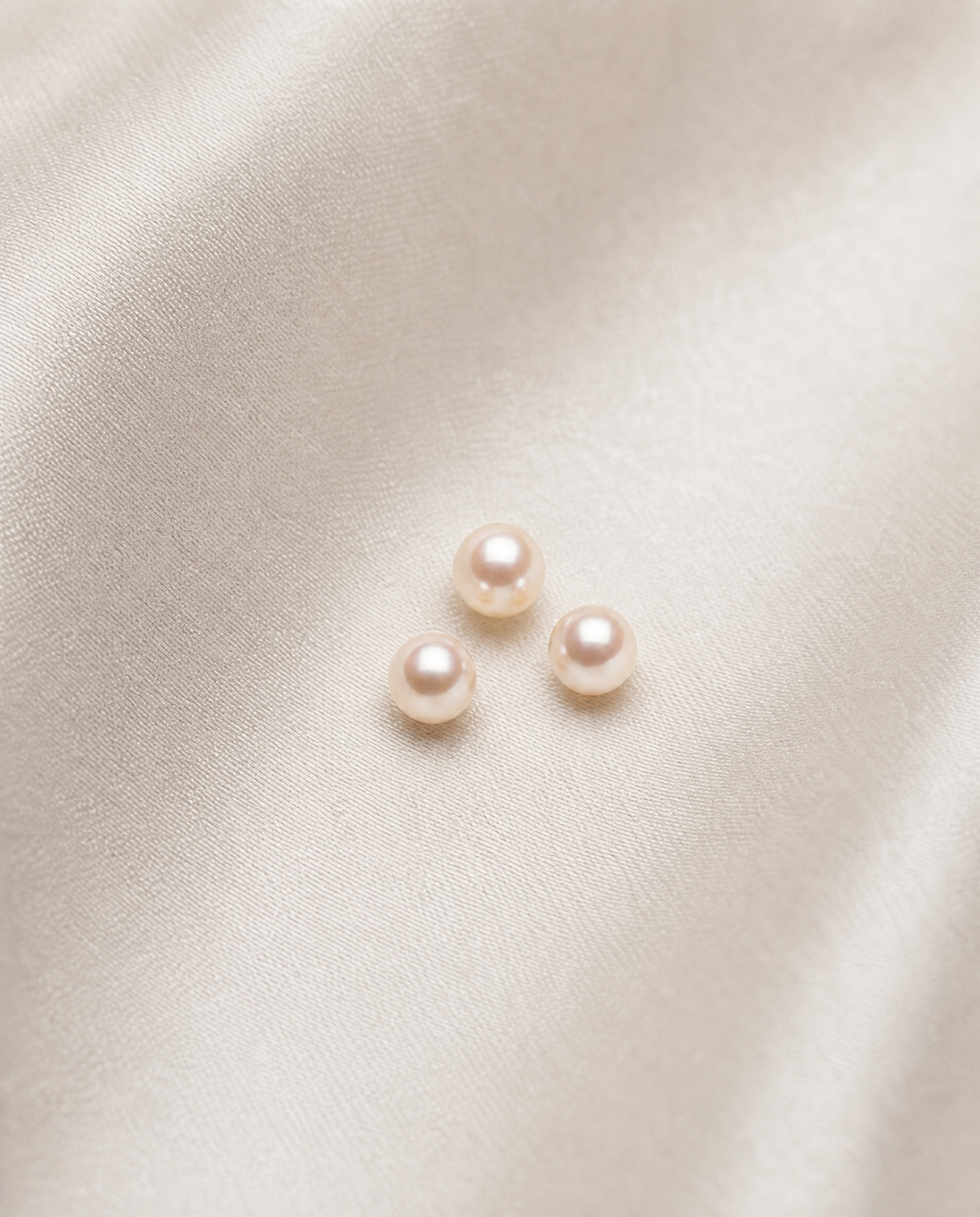 Three white pearls highlighting their lustre, quality, and elegance.
