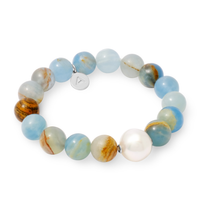 Beaded bracelet with blue and orange beads and a white pearl on a white background