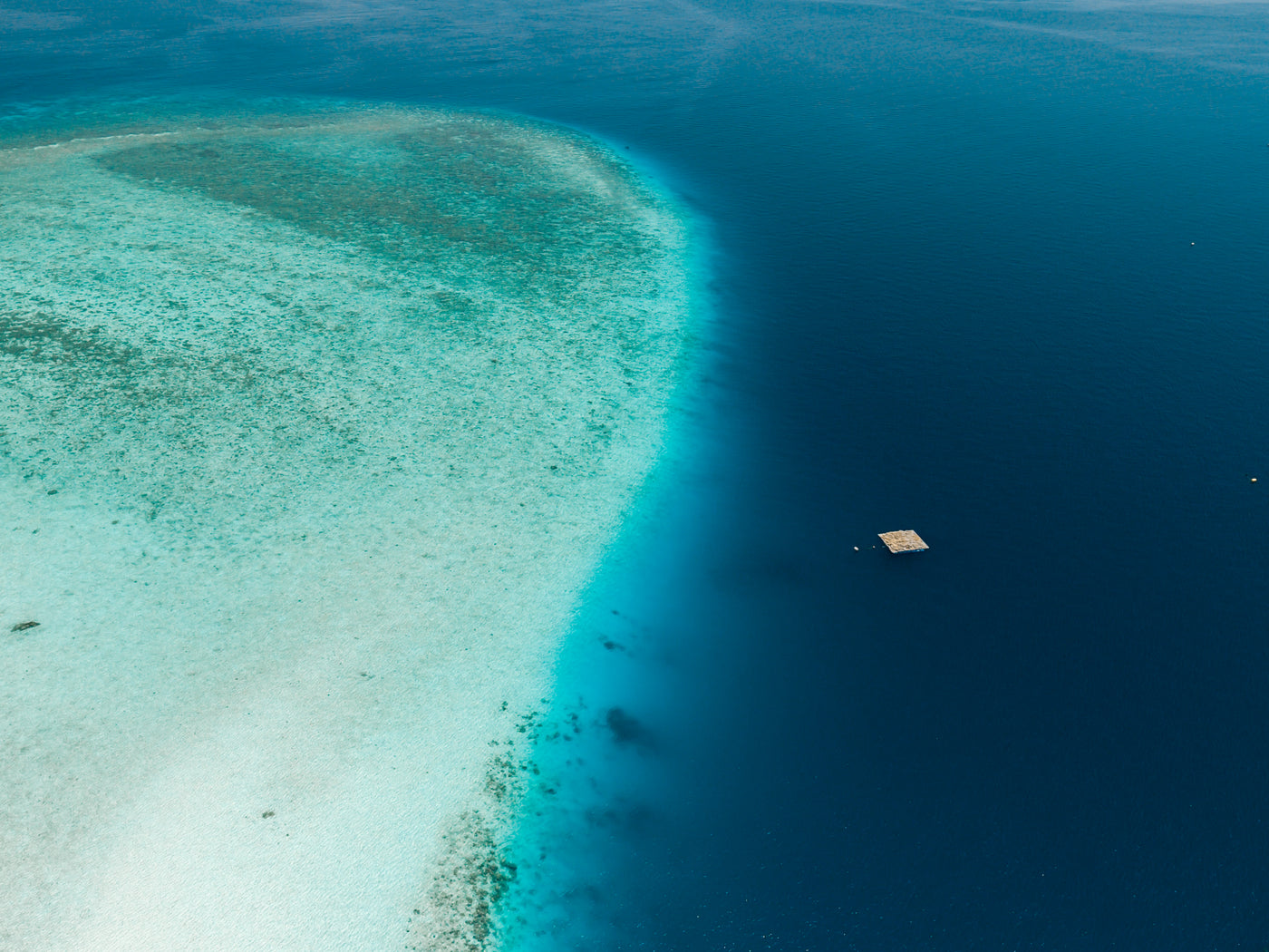Aerial view of a small island surrounded by clear turquoise water.