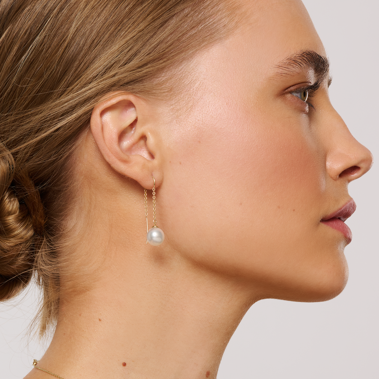 On model The 14K Yellow Gold threaded chain earrings feature 9mm South Sea pearls in the NL1 shape, with a B-grade white colour. These elegant earrings have a total height of 48mm and offer a refined, modern design suitable for various occasions.