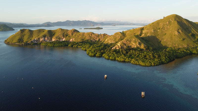 Birds eye view of hilly island being lit by the sunlight 