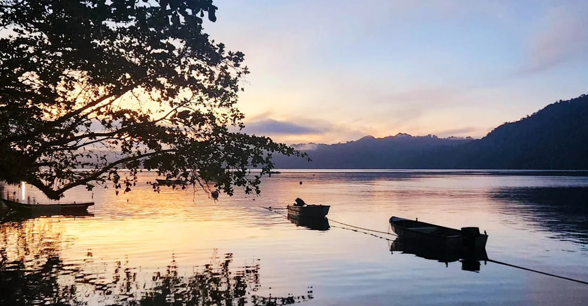 Sunsetting over the sea shores with two mored boats floating 