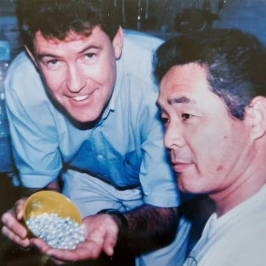 Man holding pearls in a cup and his hand. 