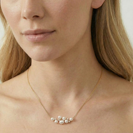 Woman wearing a gold necklace with pearls