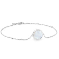 A silver bracelet with a round mother of pearl shell inset, on a white background.