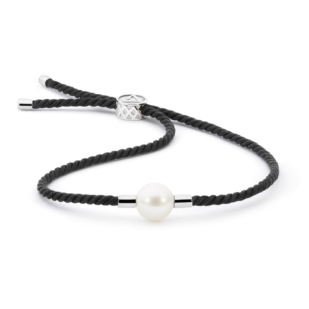 Elegant bracelet featuring a 10mm South Sea pearl embraced by handwoven black Japanese silk cord, symbolizing clarity and focus. The pearl's pristine beauty represents sustainable, biodiverse waters, inspired by the midnight seas where Atlas farms are located.
