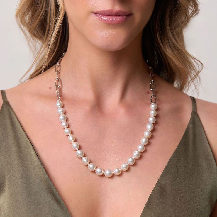 Pearl necklace worn by a person against a neutral background