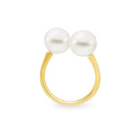 An 18K yellow gold ring with two white South Sea pearls set on opposite sides of an adjustable band.